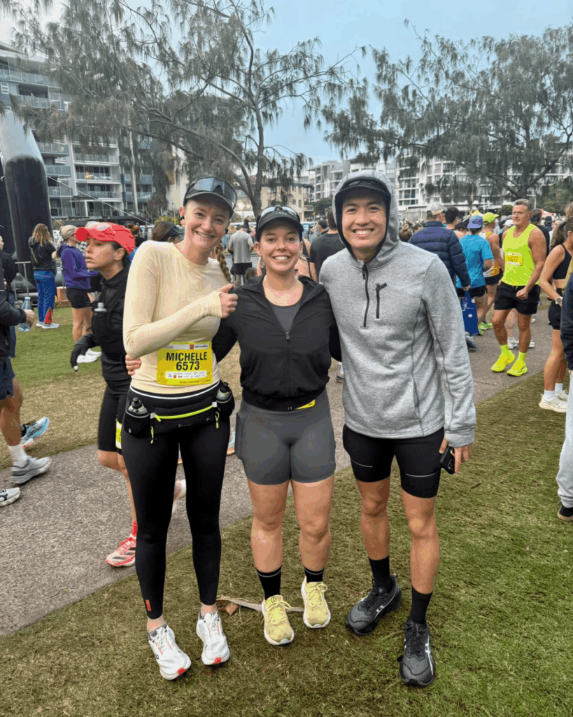Three Action Rehab hand therapy runners posing at a marathon event, highlighting upper body awareness in running